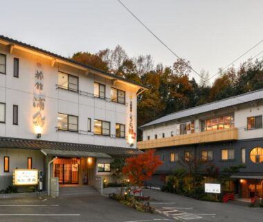 Exterior facade of Onsen Urashima with parking and hillside trees in Hiroshima Chūgoku