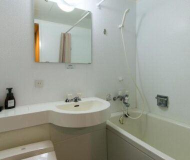 Small bathtub, sink and mirror in ryokan bathroom at Onsen Urashima, Hiroshima