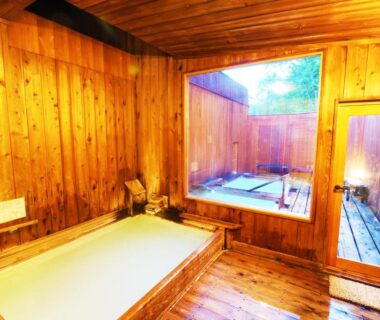 Wooden indoor soaking tub with adjacent enclosed outdoor bath at Onsen Yado Misuzuso, Nagano