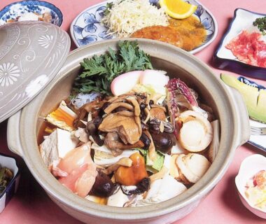 Clay nabe hot pot with mushrooms, tofu, and side dishes at Onsen Yado Misuzuso, Nagano