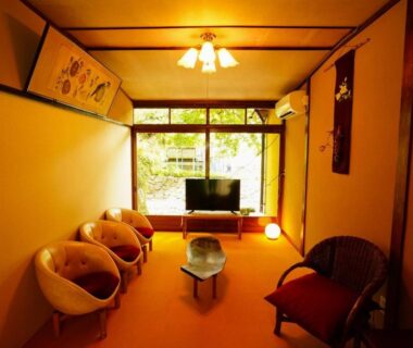 Tatami room with low table, cushioned chairs and garden view at Onsen Yado Mizuguchi, Chubu Japan