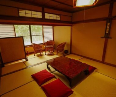 Traditional tatami room with low table, zabuton cushions and shoji screens at Onsen Yado Mizuguchi in Shizuoka