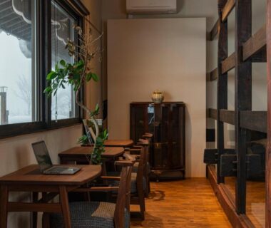 Tatami seating area with low wooden tables, shoji windows and cabinet at Onsen and Garden Nana, Ishikawa