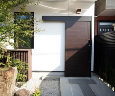 Gravel walkway, stone basin, wooden door and garden foliage at Onya Kaede in Kyoto, Kansai