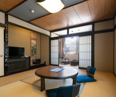 Tatami room with low round table, zaisu chairs, shoji screens and tokonoma alcove