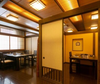 Wood-paneled dining space with shoji screens and both chair and low table seating at Onyado Hisui in Gifu