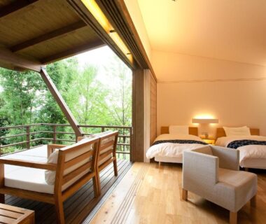 Open room with twin beds and wooden balcony seating at Onyado Satsuki, Kumamoto, Kyūshū