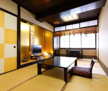 Traditional tatami room with low table, cushions and sliding doors at Onyado Takasago in Saga, Kyushu, Japan