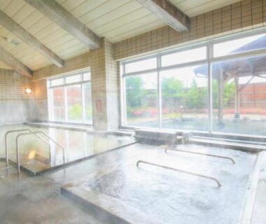 Indoor onsen with multiple baths, wooden beams and large windows at Ooedo Onsen Monogatari Aizu Fukushima Tōhoku