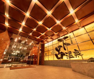 Warm lit ryokan lobby entrance with wooden panels at Ooedo Onsen Monogatari Gero Bekkan, Gifu