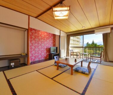 Traditional tatami room with low table and cushions at Ooedo Onsen Monogatari Hotel Shinko in Yamanashi