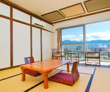 Traditional tatami room with low table, cushions, shoji screens and balcony overlooking mountain landscape in Yamanashi