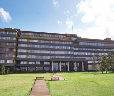 Multi-story building with lawn and central walkway leading to Ooedo Onsen Monogatari Nagayama in Ishikawa, Chūbu, Japan