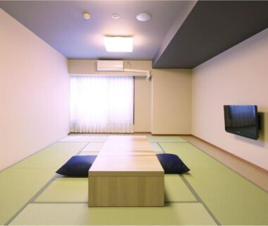Minimal tatami room with low table, floor cushions and wall-mounted TV, Ooedo Onsen Monogatari Premium Atami, Shizuoka