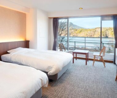 Twin beds with balcony chairs at Ooedo Onsen Monogatari Enakyo, mountain view in Gifu