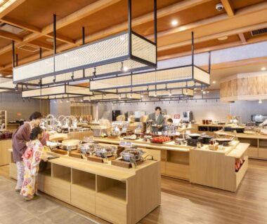 Guests in yukata at buffet with wooden counters and lantern lights, Ooedo Onsen Monogatari, Gifu, Chūbu, Japan