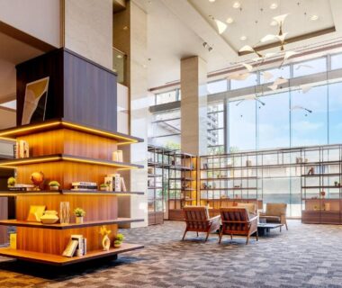 Ryokan lobby with tall windows, lounge seating and wooden shelving at Ooedo Onsen Monogatari Ito, Shizuoka