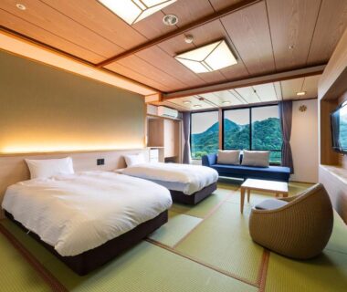 Spacious tatami room with twin beds, low seating, sliding screens and mountain view in Kinosaki, Hyōgo