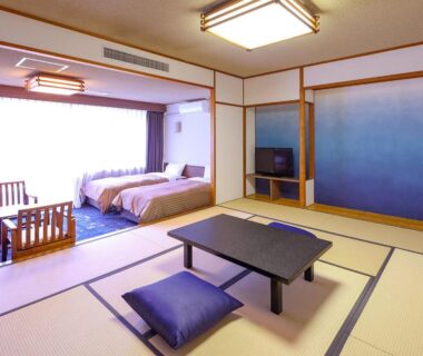 Tatami living area with low table and twin beds at Ooedo Onsen Monogatari Premium Kinugawa Kanko Hotel Tochigi