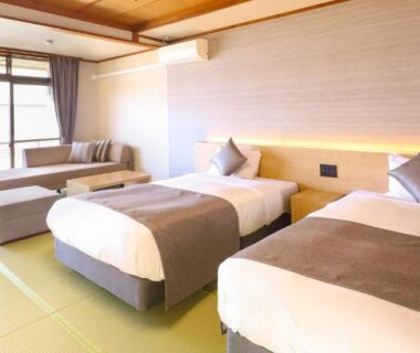 Twin beds on tatami with sofa and sliding doors at Ooedo Onsen Monogatari Premium Yamashitaya Ishikawa
