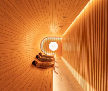 Curved slatted wooden sauna interior with circular light and bench seating at ryokan in Ishikawa, Chūbu Japan