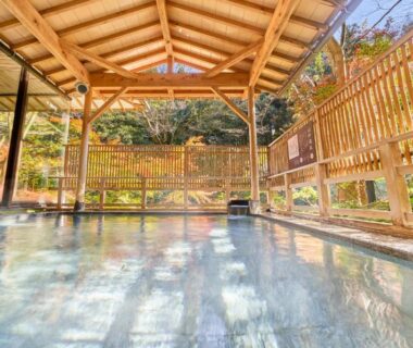 Roofed outdoor onsen with wooden beams and fence at Ooedo Onsen Monogatari, Ishikawa