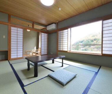 Tatami room with low table and cushions at Ooedo Onsen Monogatari Shinshu Kakeyu, Nagano, Chūbu