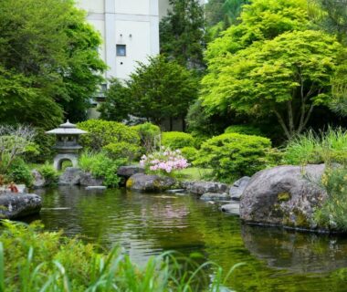 Reflective pond with stone lantern and rocks at Ooedo Onsen Monogatari Shinshu Kakeyu in Nagano