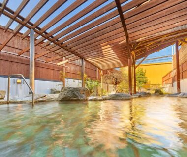 Covered onsen bath with wooden pergola and stone pools at Ooedo Onsen Monogatari Ureshinokan, Saga