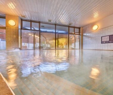 Tiled indoor onsen with glass wall at Ooedo Onsen Monogatari Ureshinokan in Saga