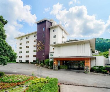 Multi-story ryokan exterior with entrance canopy and landscaped grounds at Ooedo Onsen Monogatari Yamanaka Saichoraku, Ishikawa