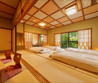 Tatami room with futon bedding, shoji screens and garden view at Ooedo Onsen Monogatari Yamanaka Saichoraku, Ishikawa