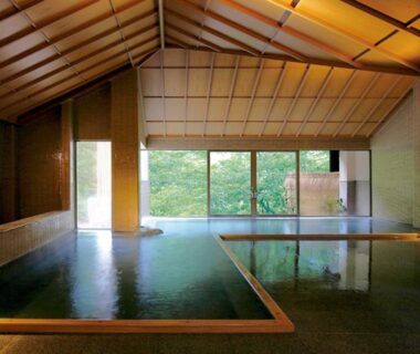 Spacious indoor onsen with wooden ceiling and garden view at Ookawaso in Fukushima Tōhoku
