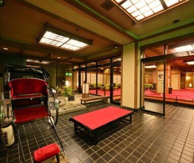 Traditional entrance with rickshaw, red seating, tatami area and shoji screens at Osakaya Ryokan in Gunma, Kantō