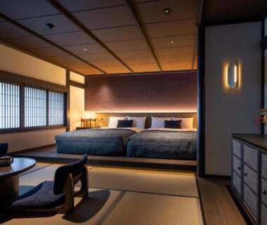 Tatami room with two beds, low table, shoji windows and warm lighting at Osawayama Onsen Osawakan, Niigata