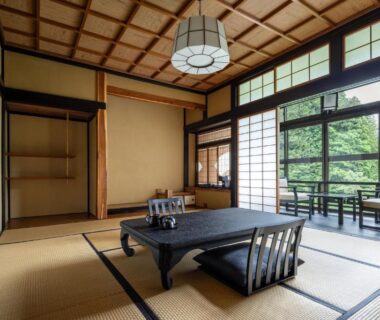 Traditional tatami room with low table, shoji screens and floor chairs, balcony overlooking garden at Osawayama Onsen Osawakan in Niigata