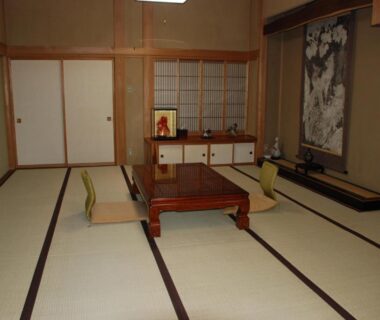 Traditional tatami room with low table, zaisu seating and tokonoma at Oshi Ryokan, Nagano