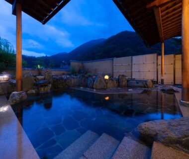 Evening outdoor onsen bath with stone steps at Otogitei Kofu in Nagano mountains