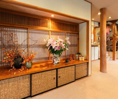 Wooden lattice screen and floral arrangement on low cabinet at Otowaya Ryokan entrance, Niigata Chūbu