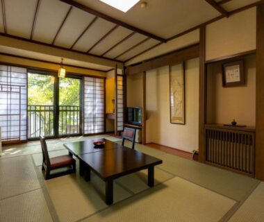 Traditional tatami room with low table, shoji screens and balcony view at Otowaya Ryokan, Niigata