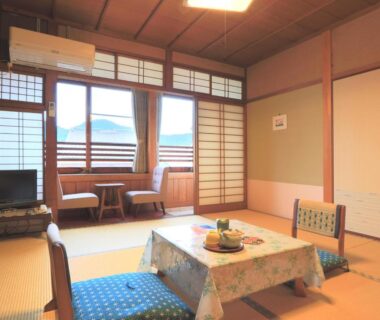 Tatami room with low table, floor cushions and shoji screens at Ougiya Ryokan in Hyōgo, Kansai