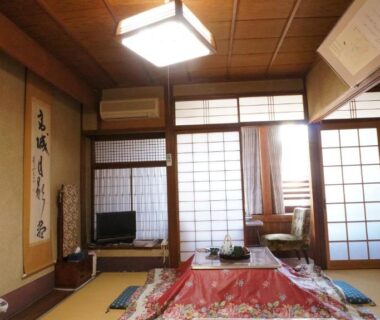 Traditional tatami interior with shoji screens, low table and kotatsu blanket at Ougiya Ryokan in Hyōgo