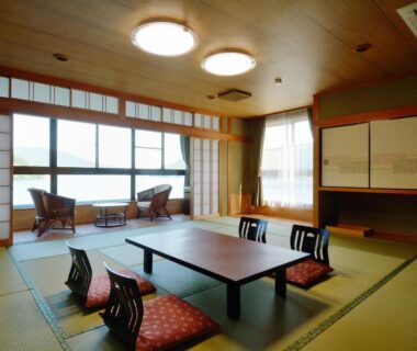 Tatami room with low table, cushions, shoji screens and window seating at Owase Seaside View, Mie