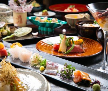 Assorted Japanese small plates and sashimi on lacquer trays at Oyado Den Rikyu in Oita