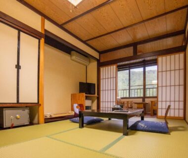 Tatami room with low table, cushions and shoji screens at Oyado Eitaro, Gifu