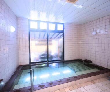 Tiled indoor onsen bath with large window at Oyado Hachibei in Gifu, Chubu