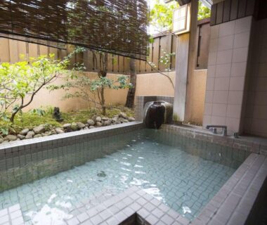 Tiled onsen bath with bamboo screen and garden at Oyado Ichifuji Tochigi
