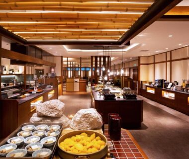 Buffet dining area at Oyado Kinkiyu Annex SUIKAZURA Hokkaidō with wooden beams, counters, bowls and warm lighting