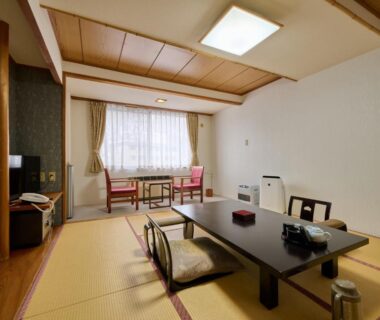 Bright tatami guest room with low table, floor chairs and window seating at Oyado Kiyomizuya in Hokkaidō