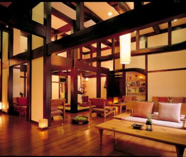 Warm wooden beamed lounge with low tables and seating at Oyado Koto No Yume in Gifu, Chūbu Japan